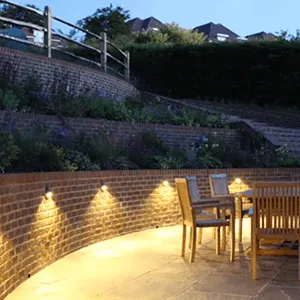 patio with a table and chairs lit up at night